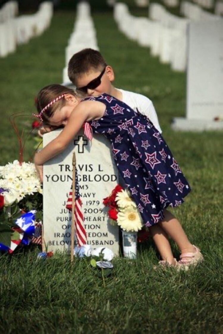 young kids hugging tombstone memorial day